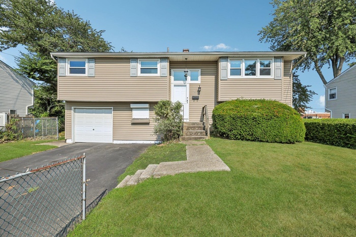 Raised ranch with driveway and an attached garage