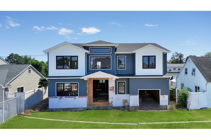View of front facade with board and batten siding and an attached garage