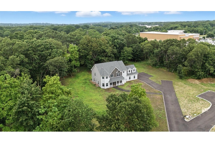 Aerial view of property and surrounding area featuring a heavily wooded area
