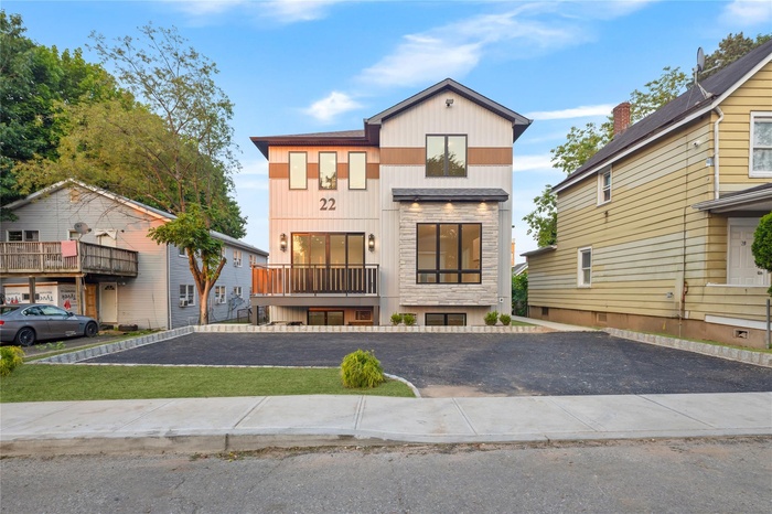 View of front of property featuring stone siding and a balcony