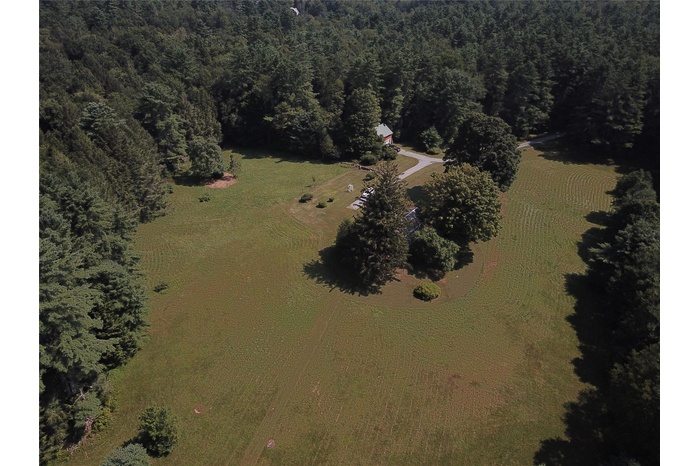 Aerial overview of property's location featuring a heavily wooded area