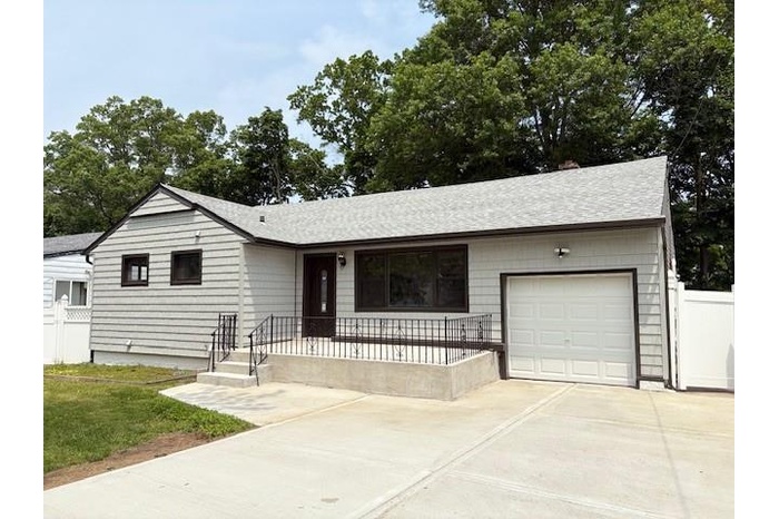 Single story home with driveway, a garage, a shingled roof, and covered porch