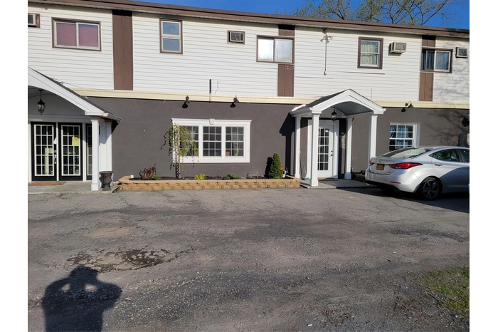 Multi-family property with stucco siding, french doors, and a wall unit AC