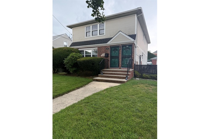Traditional-style house with brick siding and entry steps