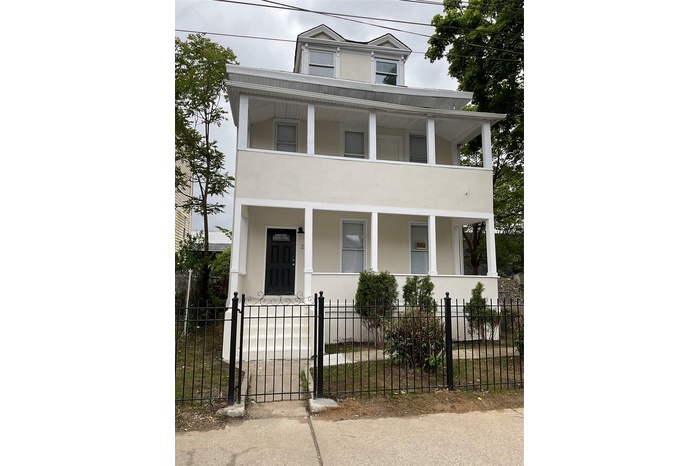 View of front facade featuring a porch, stucco siding, and a balcony