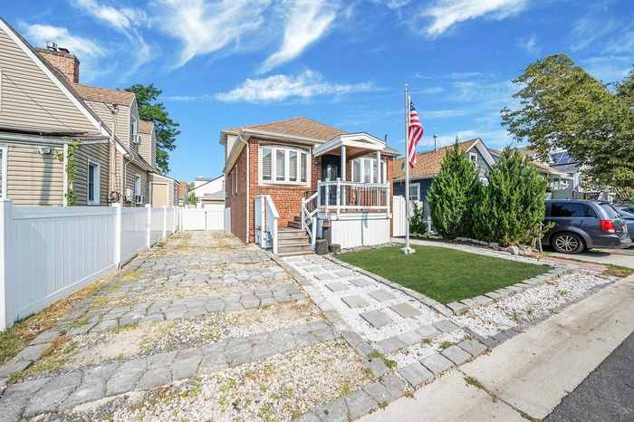 View of front of home featuring brick siding and a garage