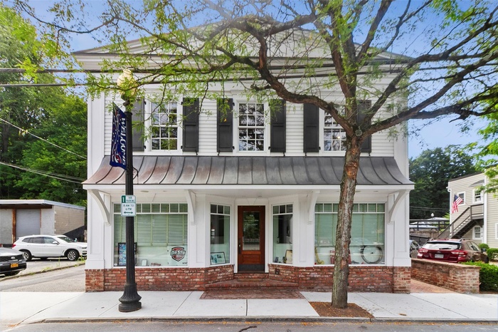 View of front of house featuring a standing seam roof, a metal roof, and brick siding