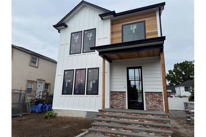 View of front facade featuring board and batten siding and a porch