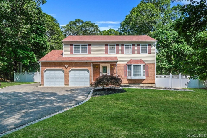 View of front facade with asphalt driveway, brick siding, and a garage