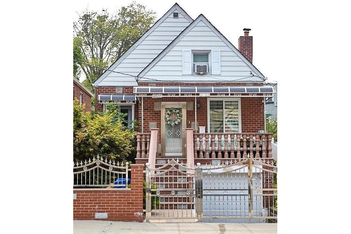 View of front of house featuring a porch, brick siding, a fenced front yard, and a chimney
