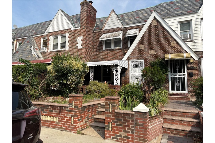 Tudor house featuring brick siding and a chimney