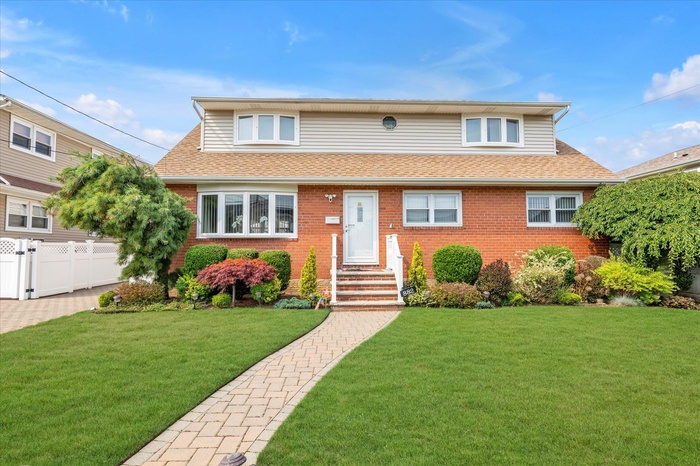 View of front of house with roof with shingles, brick siding, and entry steps