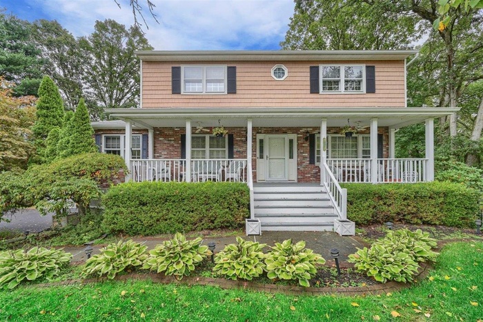 View of front of property with a porch and brick siding