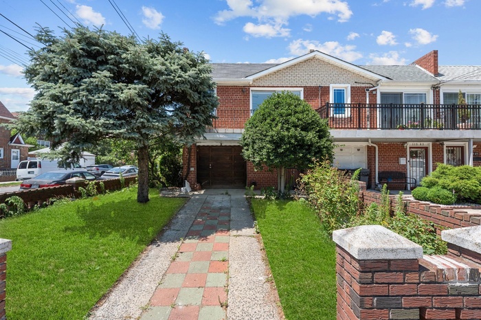 View of front of house featuring brick siding, an attached garage, a front yard, and concrete driveway