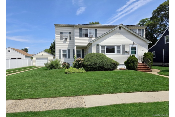 View of front of house with an outdoor structure and a detached garage