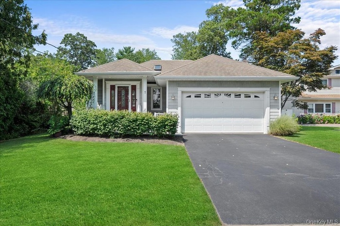 Ranch-style home with driveway, a front lawn, a garage, and a shingled roof