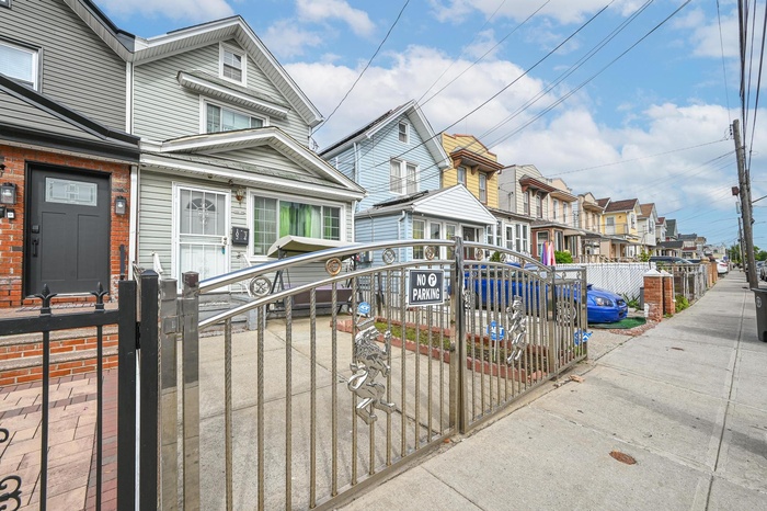 View of front of house featuring a residential view, a fenced front yard, and a gate