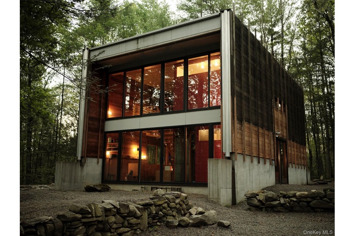 Rear view of house with view of wooded area