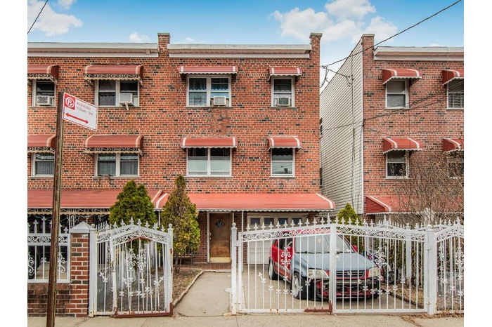 Townhome / multi-family property with an attached garage, fence, and brick siding