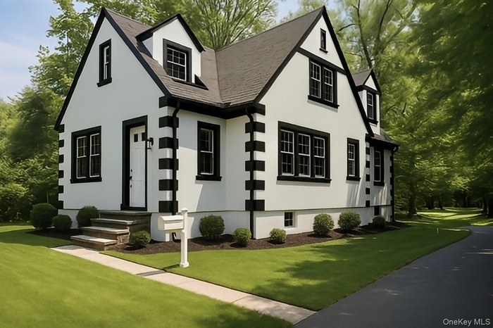 View of front facade with a front yard and stucco siding