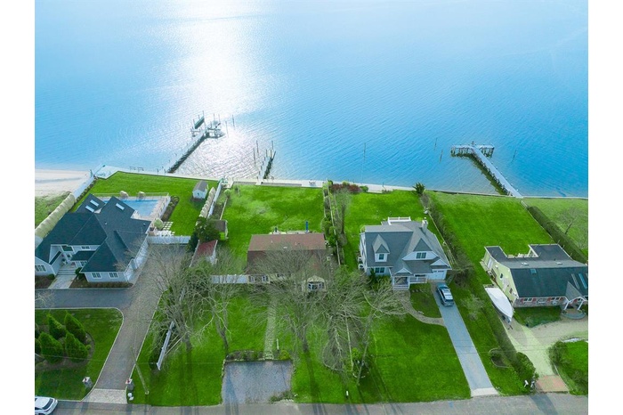 Aerial perspective of suburban area featuring a nearby body of water