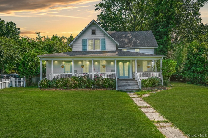 Farmhouse-style home featuring a shingled roof and a porch