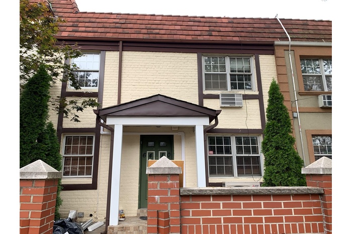 Doorway to property featuring a wall mounted air conditioner and brick siding