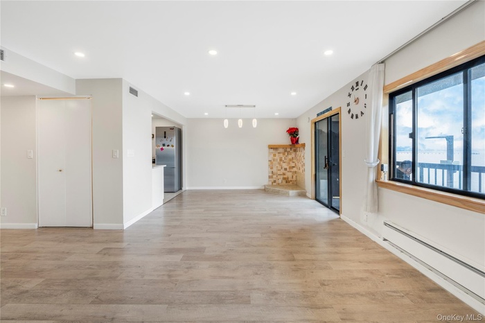 Spare room featuring a baseboard radiator, recessed lighting, and light wood finished floors