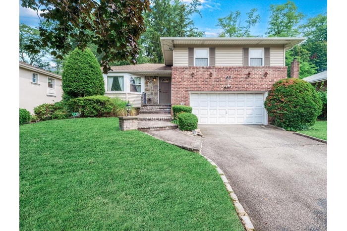 View of front facade with 2 car garage and front yard