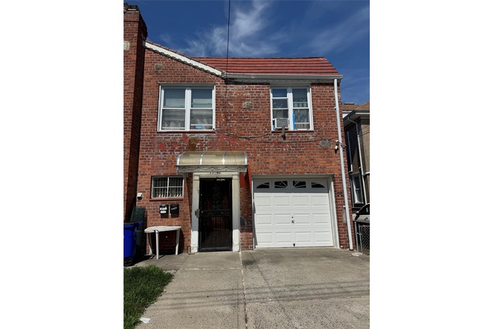 Multi unit property with driveway, brick siding, and a garage