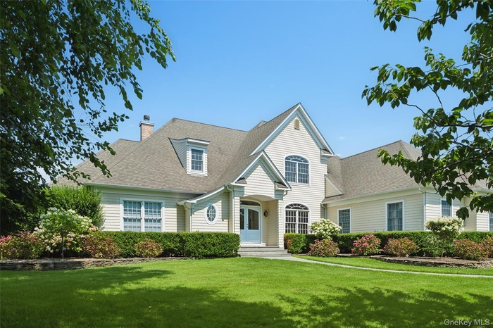 View of front of house featuring a shingled roof, a front lawn, and a chimney