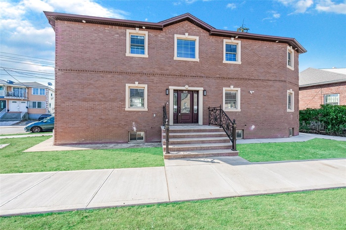 View of front of property featuring brick siding and a front lawn