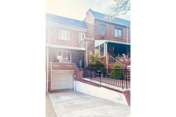 View of front of house with an attached garage, brick siding, stairway, concrete driveway, and fence private yard