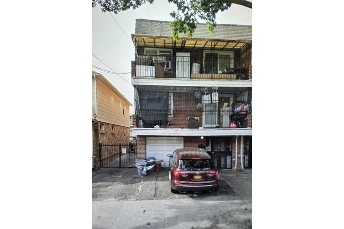 View of front facade with an attached garage, a balcony, driveway, and brick siding