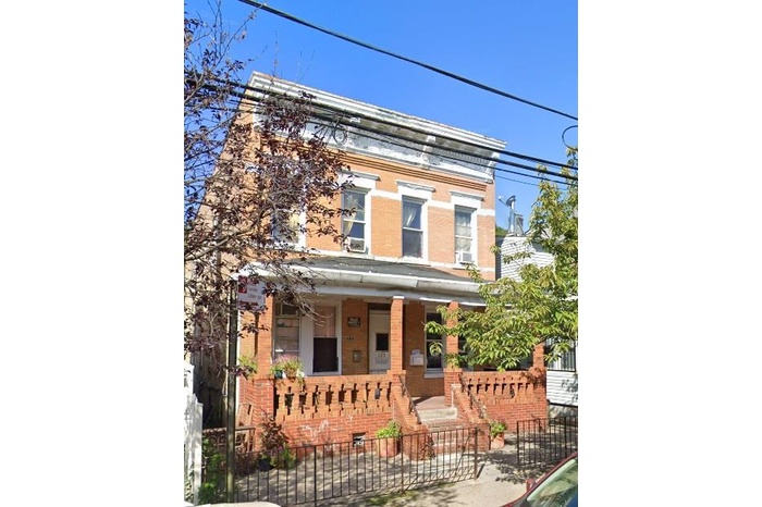 View of front of house with brick siding, a porch, and a fenced front yard