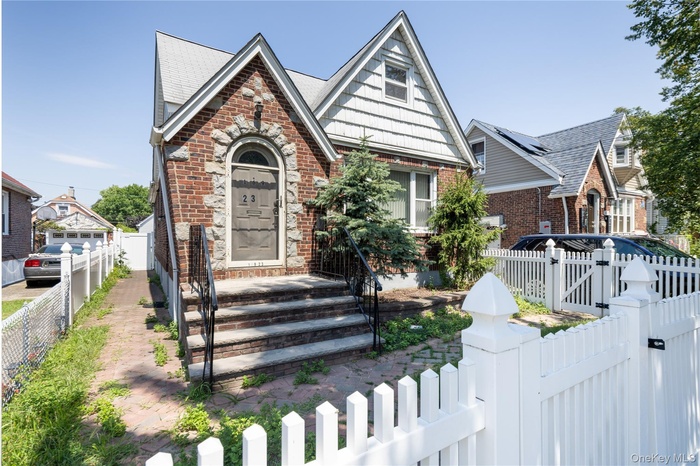 English style home with a gate and brick siding