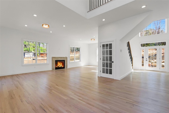 Living room with a gas fireplace, hardwood floors, and recessed lighting