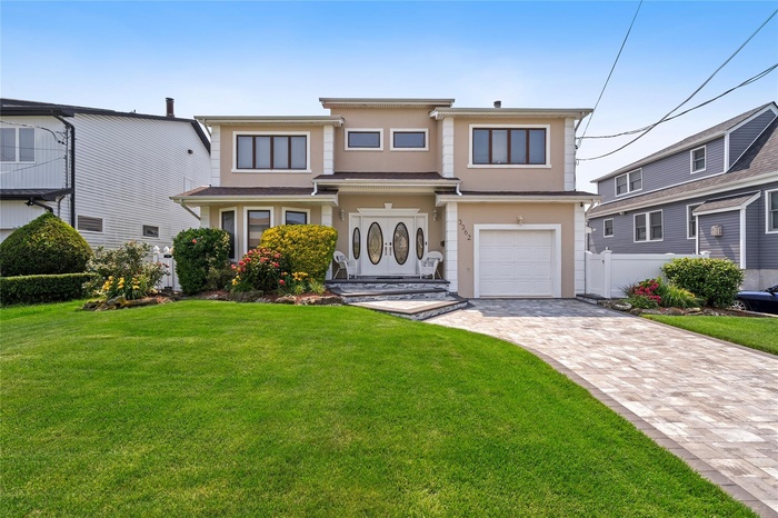 View of front of house featuring stucco siding, an attached garage, and driveway