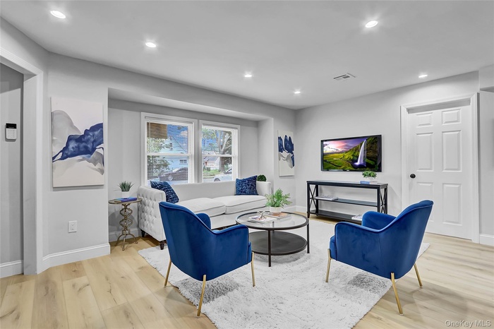 Living area featuring wood finished floors and recessed lighting