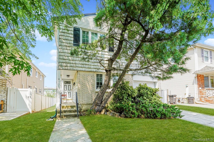 View of front of house featuring a gate and brick siding