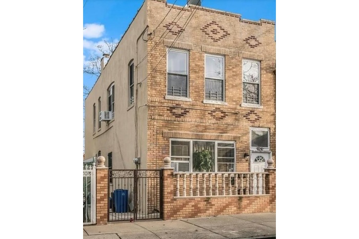 View of property exterior featuring a gate, brick siding, stucco siding, and a fenced front yard