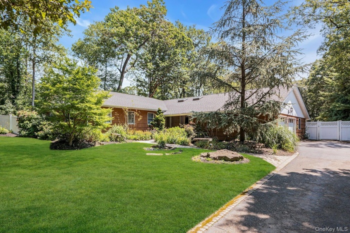 View of front of house featuring driveway, a garage, and roof with shingles