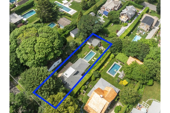 Aerial overview of property's location with nearby suburban area and property parcel outlined