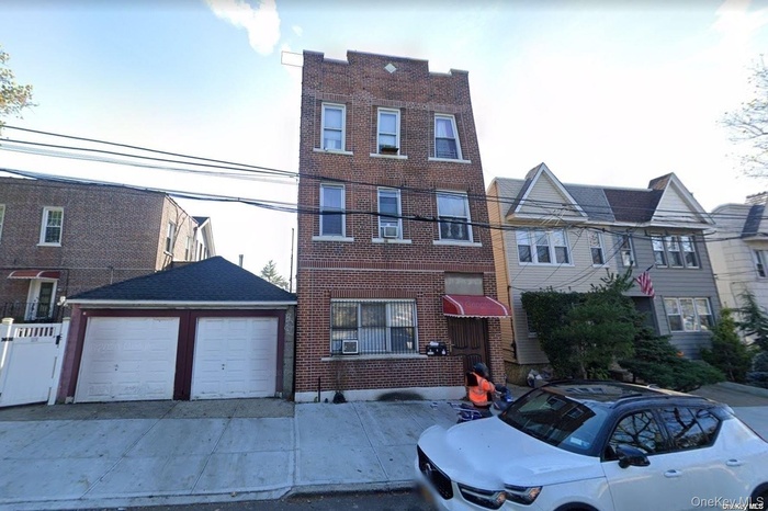 Townhome / multi-family property featuring a garage and brick siding