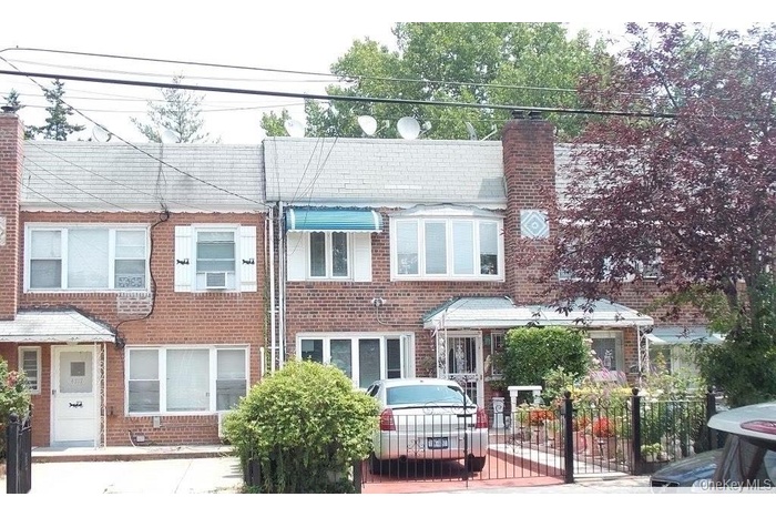 View of front of property with a chimney and brick siding