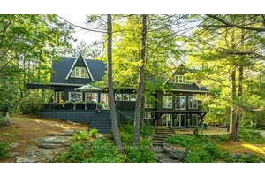 Immerse yourself in the tranquility and elegance of this architecturally inspired home, perfectly nestled into its natural surroundings on the pristine shores of Skootamatta Lake.