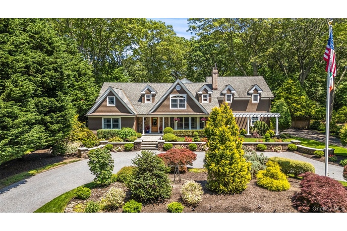 Shingle-style home with a porch and a chimney