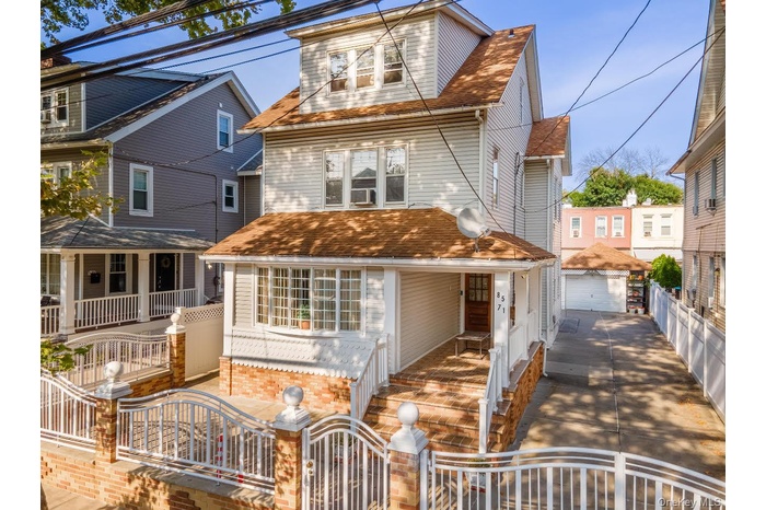 View of front facade with a porch, a fenced front yard and a gate