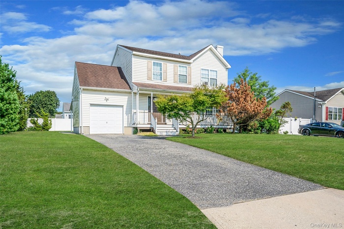 View of front of property with covered porch, asphalt driveway, a garage, and a chimney