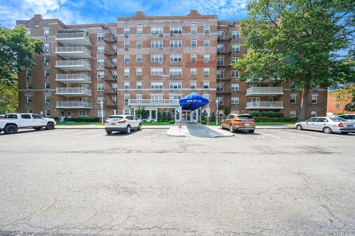 View of apartment building / complex featuring uncovered parking